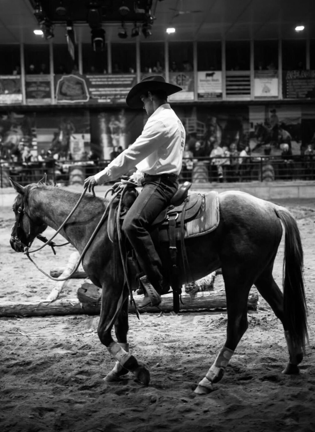 A rider walking his horse through an indoor arena