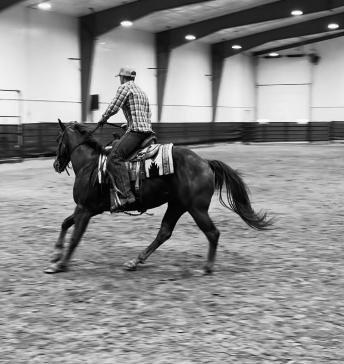Jon Anderson loping his horse in an indoor arena